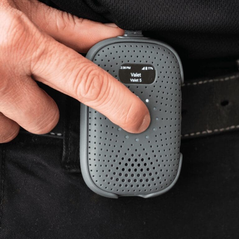 Person pressing button on RelayM clipped to belt